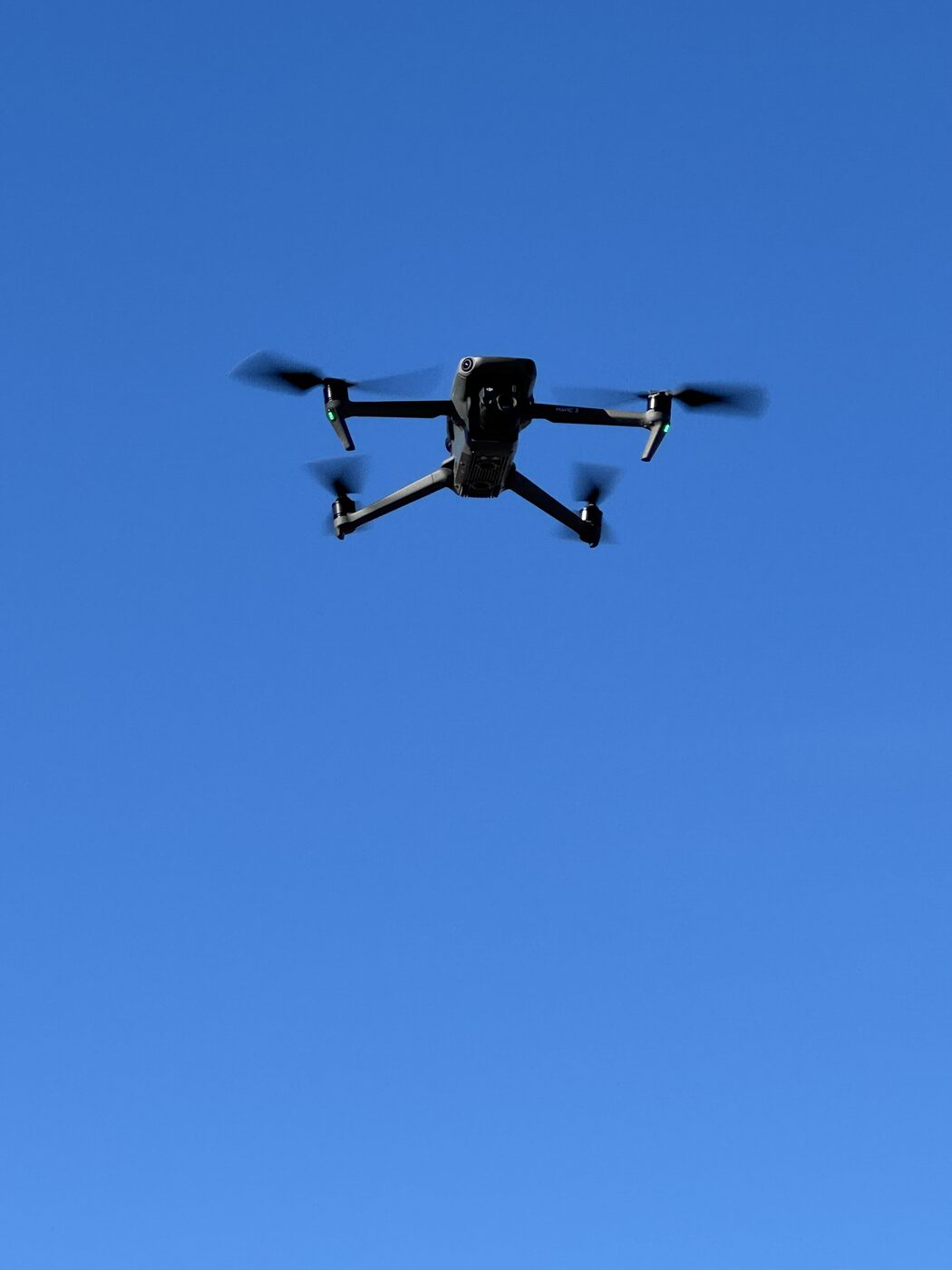 DJI Mavic-drönare i luften under takinspektion mot klarblå himmel